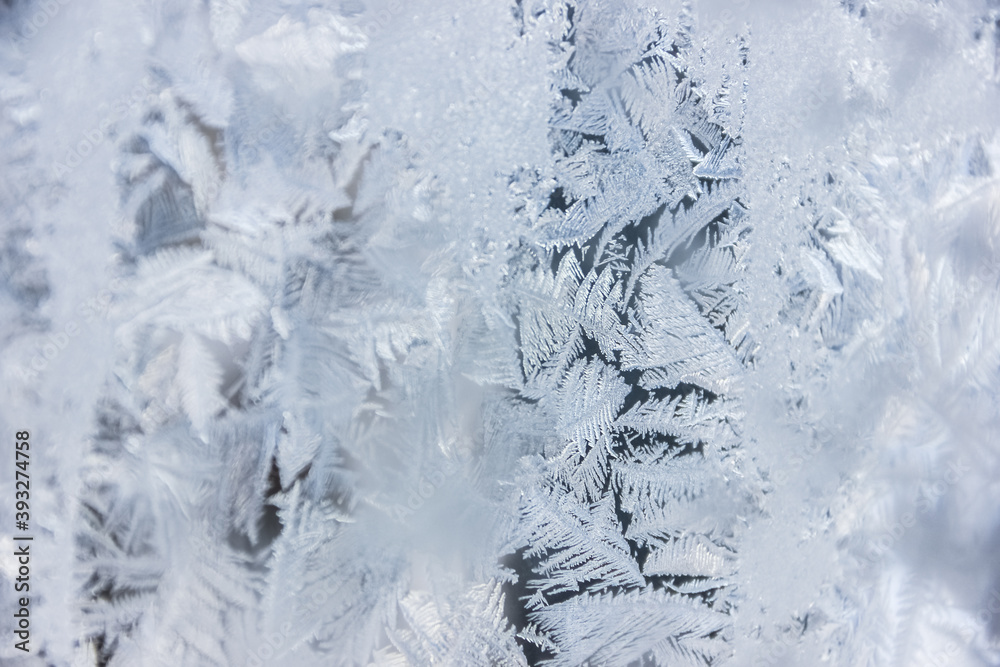 Texture of blue frost on a glass window. Frosty cold weather. White ice patterns texture close-up. New year and Christmas background Texture of blue frost on a glass window. Frosty cold weather. White ice patterns texture close-up. New year and Christmas background