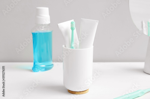 Toothbrush with mouth rinse and paste on table in bathroom