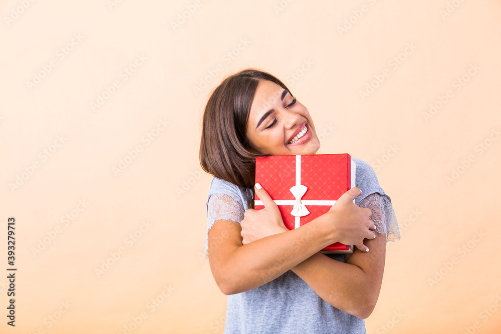 Portrait of young lovely nice sweet glamorous girl lady, wearing gray top, carrying Christmas gift box, wondering about surprise. Isolated over bright background Portrait of young lovely nice sweet glamorous girl lady, wearing gray top, carrying Christmas gift box, wondering about surprise. Isolated over bright background