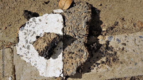 The mortar mixes with the pebbles and black asphalt, when it dry will make an interesting shapes and color, placed on the red ground, when exposed to sunlight causing a beautiful shadow to the ground