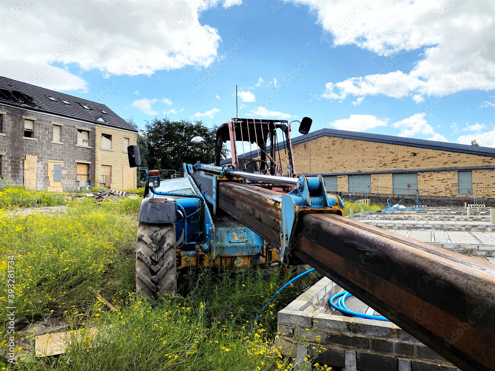 Old machinery, abandoned on waste ground, with a derelict building in the background in, Bradford, Yorkshire, UK