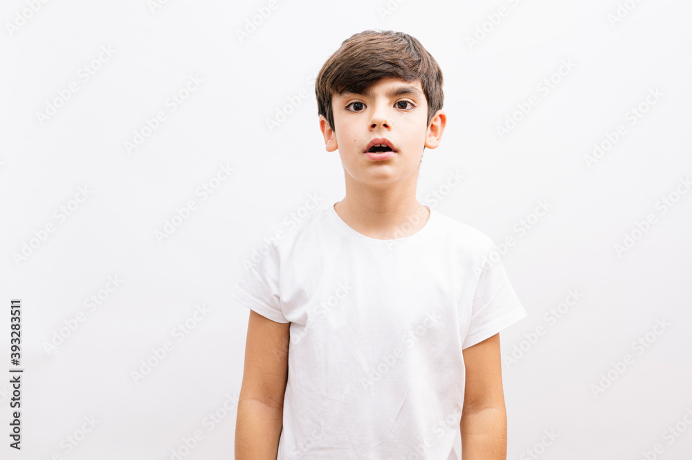 Beautiful kid boy wearing casual t-shirt standing over isolated white background afraid and shocked with surprise expression, fear and excited face. Beautiful kid boy wearing casual t-shirt standing over isolated white background afraid and shocked with surprise expression, fear and excited face.