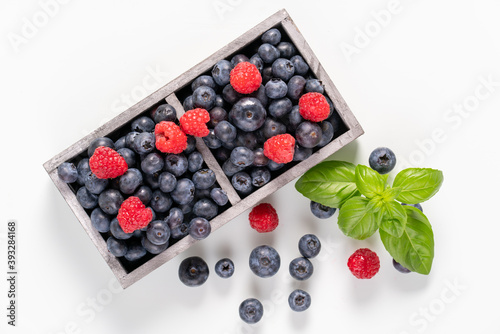blueberries and raspberries in wooden crates.