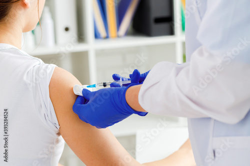 Doctor hands making a vaccination in the shoulder of patient