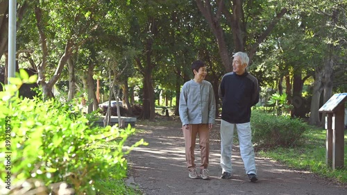 会話を楽しみながら公園を歩くシニア夫婦