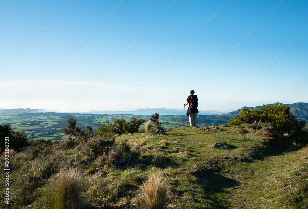 A backpacker admiring the views of Kaikoura peninsula from Mt Fyffe track, South Island, New Zealand
