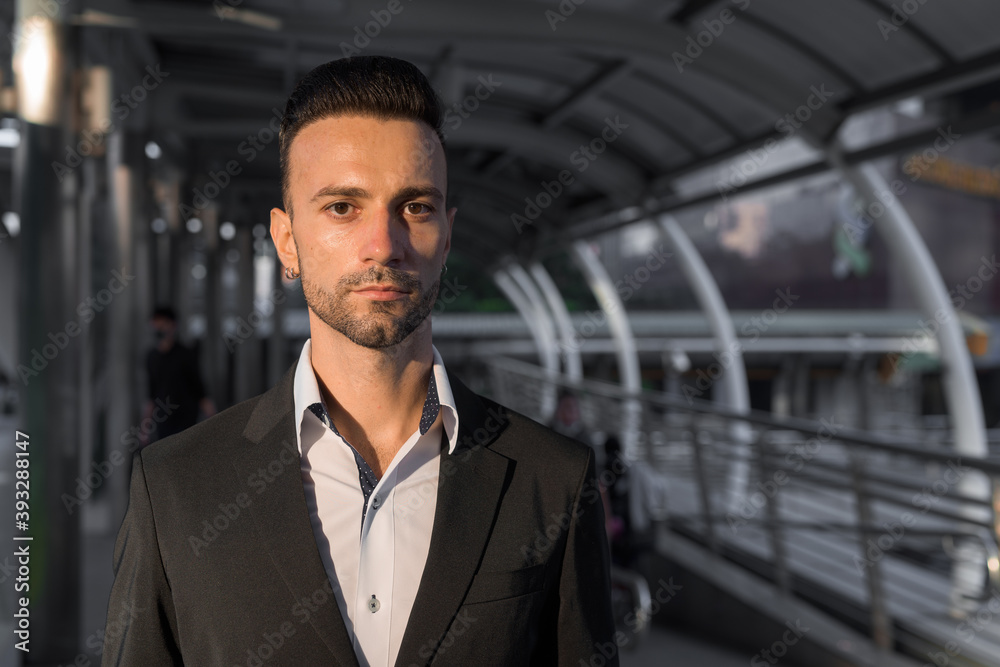 Fototapeta premium Portrait of handsome young businessman outdoors in city