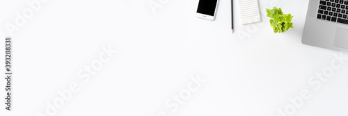 Modern workplace with laptop and accessories on white table with copyspace. Office desktop. Banner