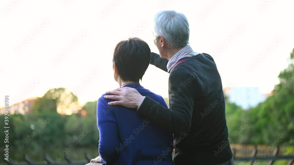 仲の良いシニア夫婦が公園で景色を眺めている。 仲の良いシニア夫婦が公園で景色を眺めている。