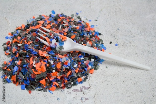 Crushed recycled plastic and fork . Plastic for further processing.Recycle! Cleaning up nature is expensive. Crushed recycled plastic in and fork.
