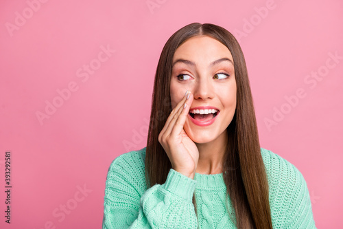 Close up photo of cheerful funky person look empty space arm near mouth teal sweater isolated on pink color background