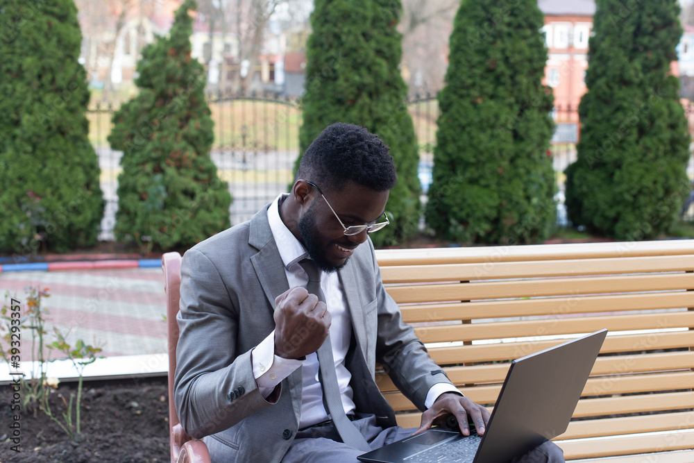 Happy African American on the street with laptop, freelancing Happy African American on the street with laptop, freelancing