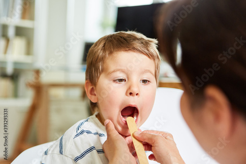 Pediatrician examines child with tonsillitis photo