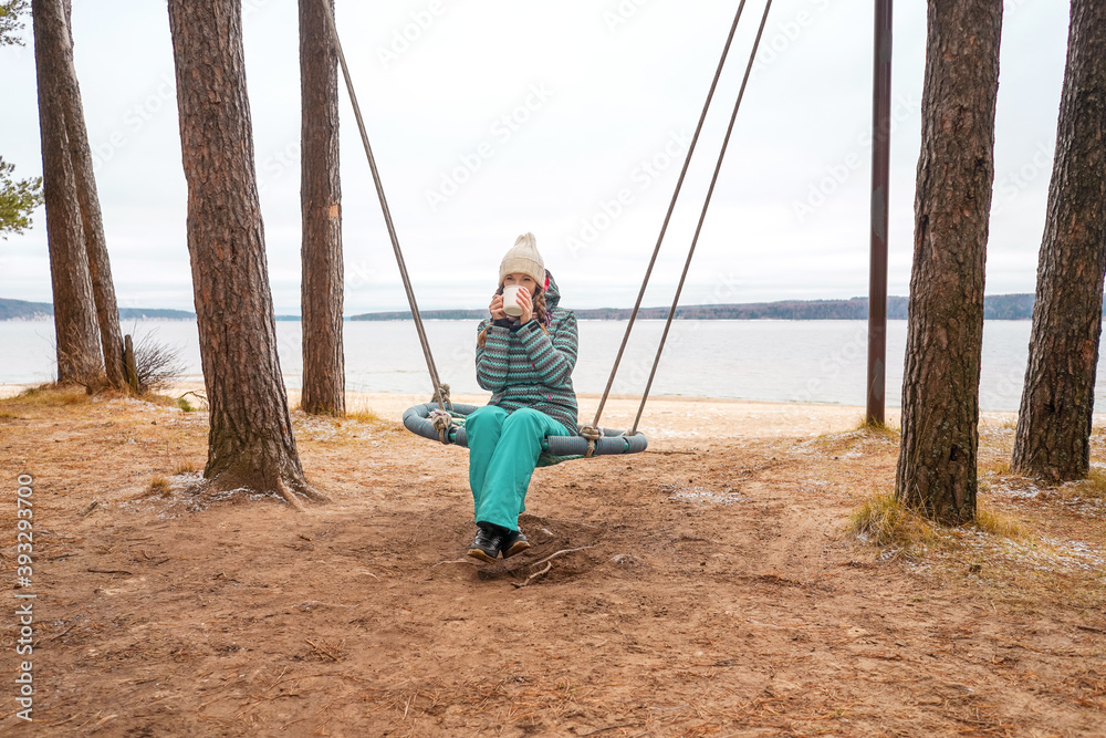 Beautiful woman with cup of tea on Swing. River on background, nature and calm. Self isolation. Beautiful woman with cup of tea on Swing. River on background, nature and calm. Self isolation.