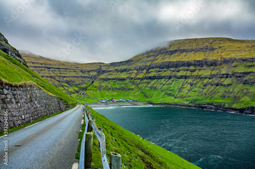 Tjornuvik village with colorful houses surrounded by green mountains in bay photo