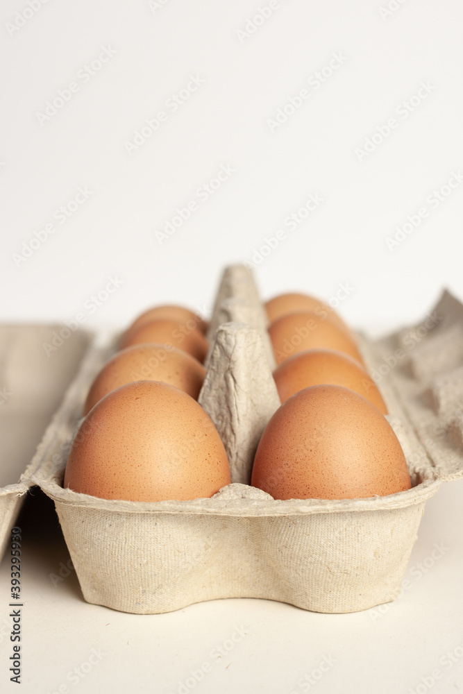 Cardboard package with not colored eggs isolated light background