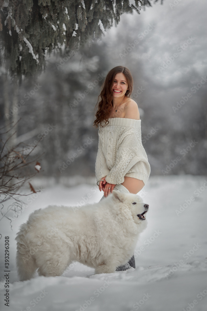 Beautiful woman with dog samoyed in winter forest Beautiful woman with dog samoyed in winter forest