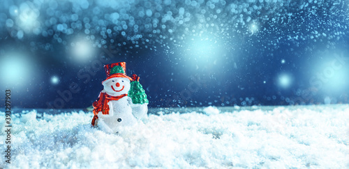 Christmas snowman in wintry background with snow.