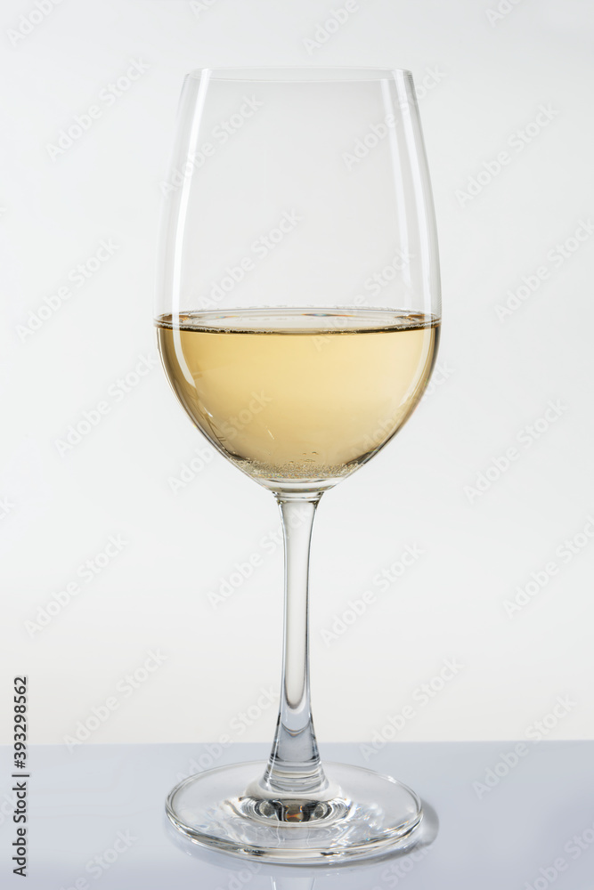 Glass of white wine on white background