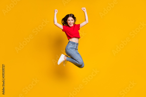 Full length photo of ecstatic girl jump win raise fists scream isolated over bright shine color background