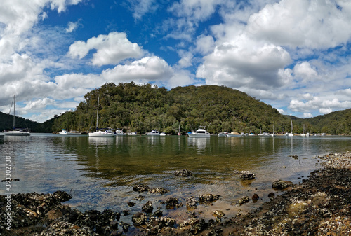 Beautiful morning panoramic view of a creek with reflections of mountains, trees, boats and blue puffy sky, Apple Tree Creek, Bobbin Head, Ku-ring-gai Chase National Park, New South Wales, Australia
 photo