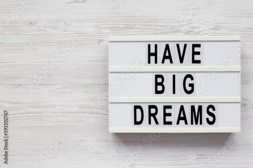 'Have Big Dreams' on a lightbox on a white wooden background, top view. Flat lay, overhead, from above. Copy space.
