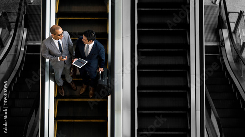 Business people discussing on an escalator