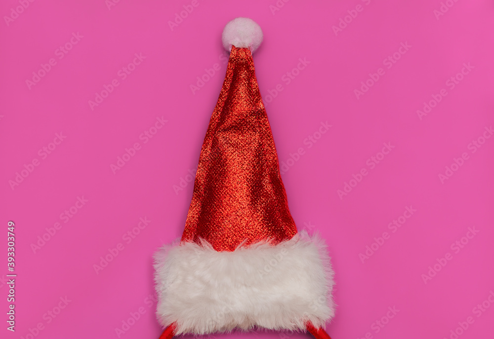 Red cap of Santa Claus on a pink background. Christmas, New Year. Flat lay, copy space, top view. Red cap of Santa Claus on a pink background. Christmas, New Year. Flat lay, copy space, top view.