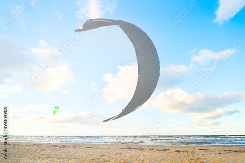 Fototapeta Naklejka Na Ścianę i Meble -  Kiteboarder preparing his kite for start on the sea beach