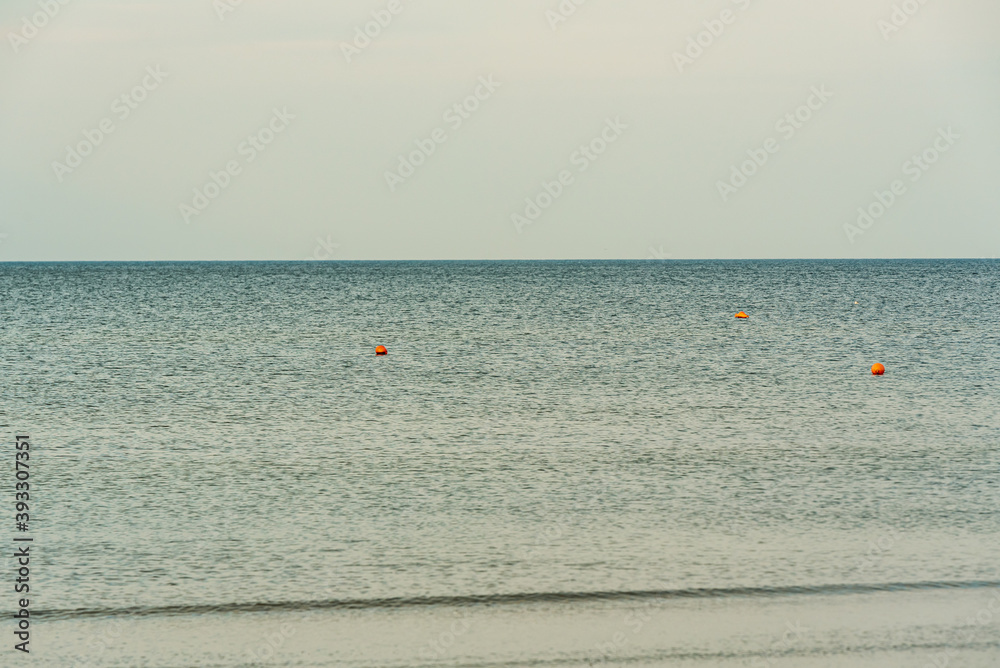 calm water surface on which orange buoys fly