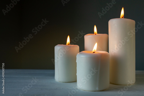 Large burning candles on a dark background.
