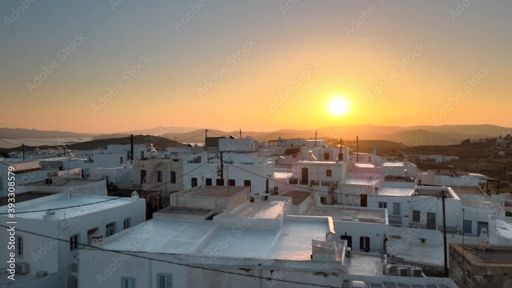 Aerial establishing shot flying over rooftops and revealing Plaka town at sunrise.