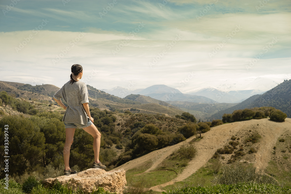 Naklejka premium Young woman looking forward to reach the Sierra Nevada Mountain peak in southern Spain