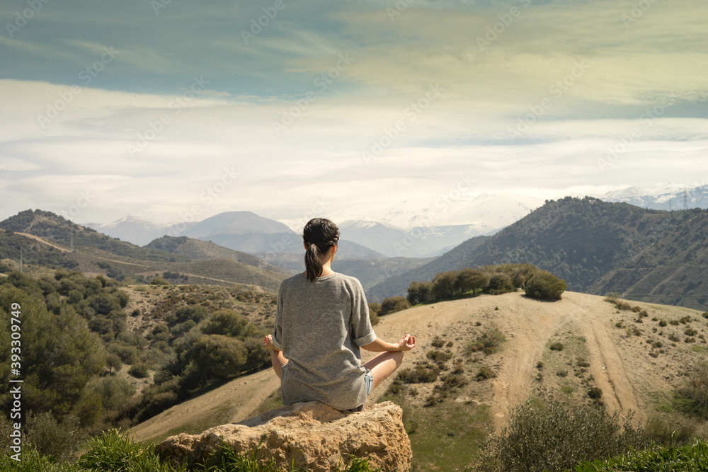 Young womanmeditating in front of Sierra Nevada Mountain