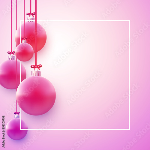 Square frame with pink christmas tree balls hanging on red ribbons.