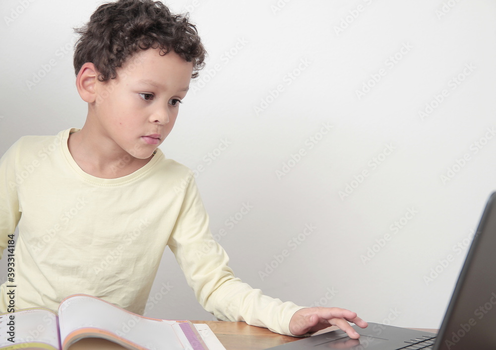 boy with book on table with laptop going back to school on white background stock photo boy with book on table with laptop going back to school on white background stock photo