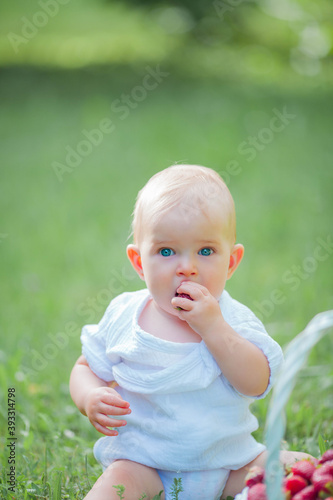 little cute girl eating strawberries from a basket outdoors © Kristina89