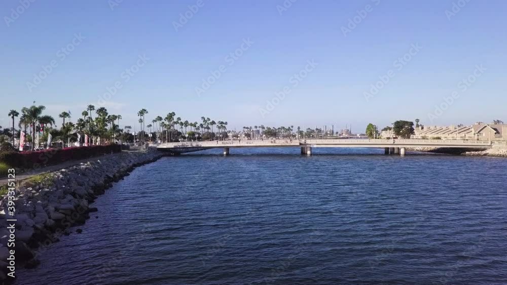 Flying towards a bridge over the San Gabriel River in Long Beach, California; people on the bridge to watch the sunset; drone view. Flying towards a bridge over the San Gabriel River in Long Beach, California; people on the bridge to watch the sunset; drone view.
