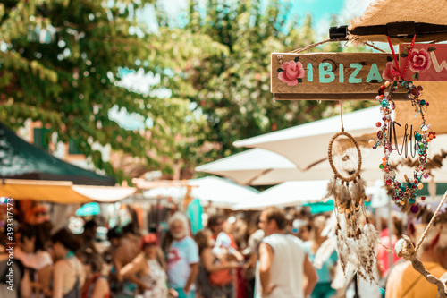 Market outside in Ibiza with a wooden sing that says ibiza on a sunny day