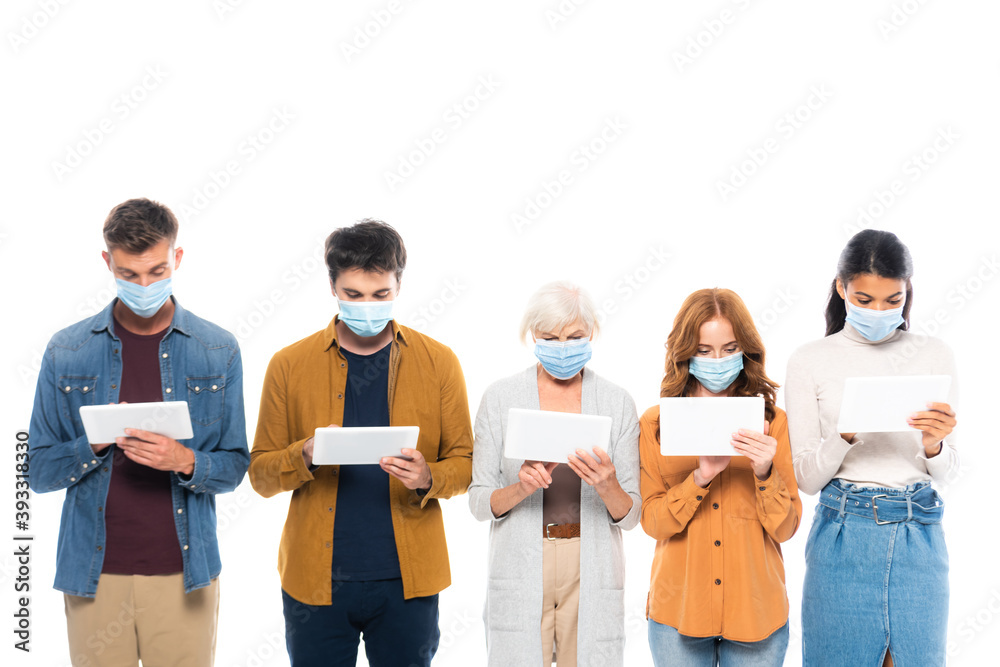 Obraz premium Multiethnic people in medical masks using digital tablets isolated on white