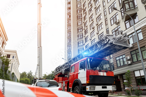 Valokuva Many fire engine trucks with ladder and safety equipment at accident in highrise tower residential apartment or office building in city center