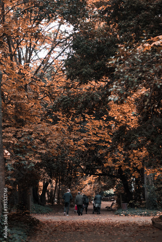 Un grupo de personas pasea en familia por un parque en otoño