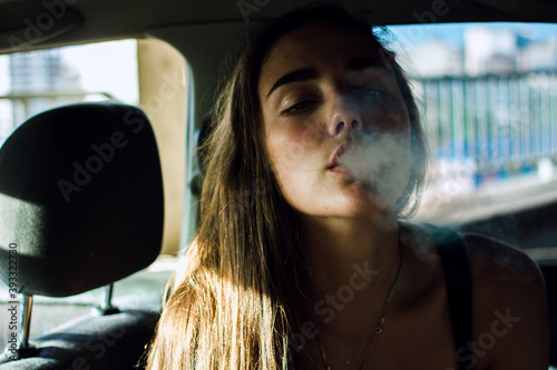 woman smoking cigarette in car. 