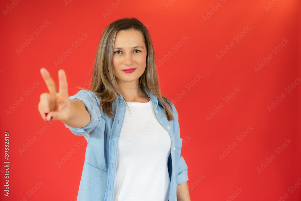 Young pretty woman in casual clothes show v-sing isolated red background Young pretty woman in casual clothes show v-sing isolated red background