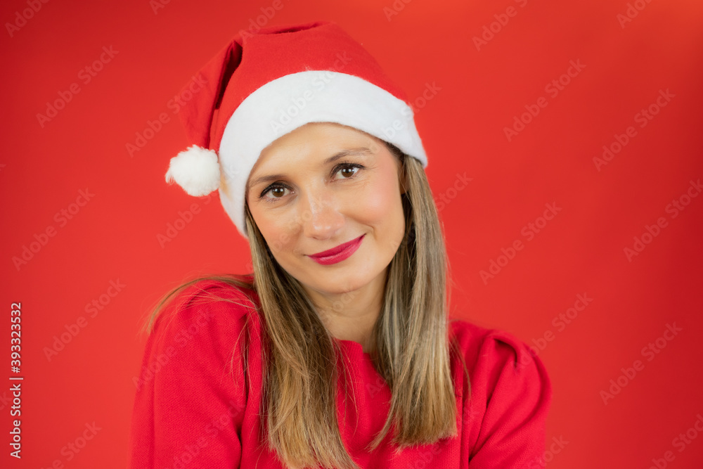 Close up portrait of a beautiful woman wearing a santa hat over red background. Close up portrait of a beautiful woman wearing a santa hat over red background.