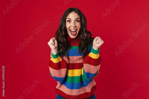 Excited beautiful brunette girl posing with clinched fists