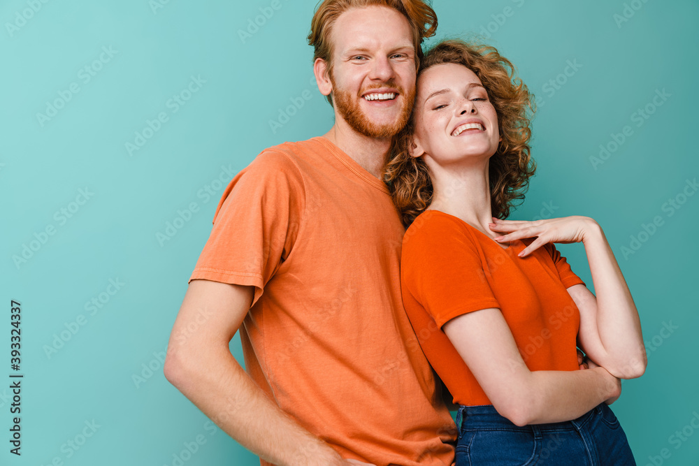 Fototapeta premium Young happy redhead couple smiling and hugging at camera