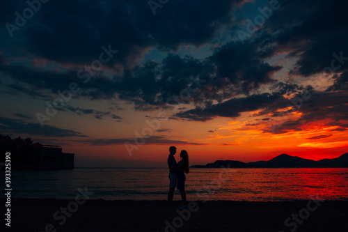man and woman hugging on the on the beach at sunset
