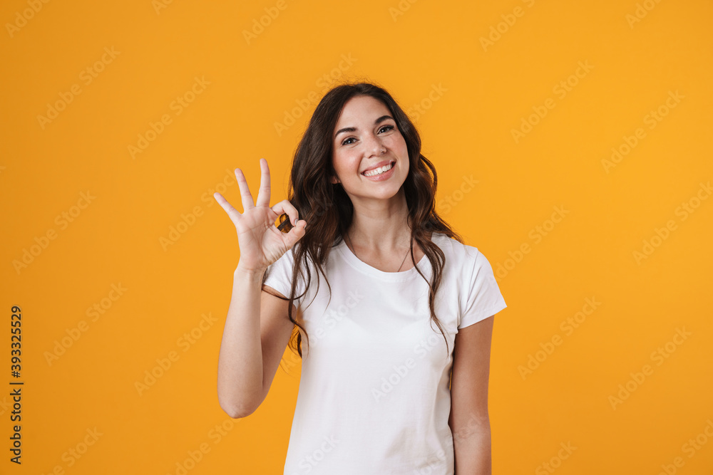 Cheerful beautiful girl gesturing ok sign and smiling on camera Cheerful beautiful girl gesturing ok sign and smiling on camera