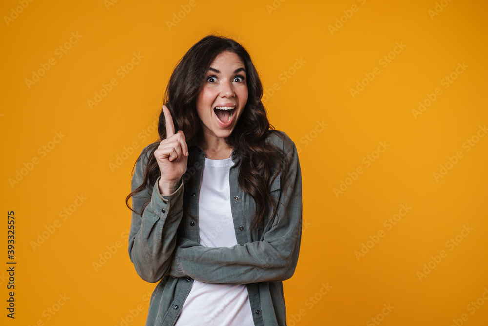 Excited beautiful girl exclaiming and pointing finger upward Excited beautiful girl exclaiming and pointing finger upward